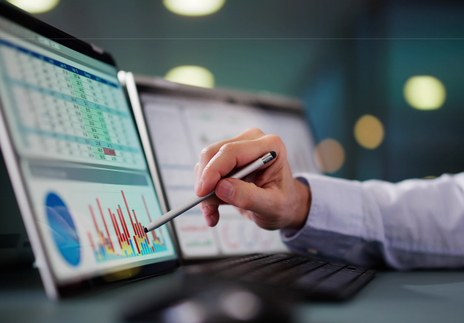Managing the data lifecycle: analyst reviewing archive reports and charts on a touchscreen laptop